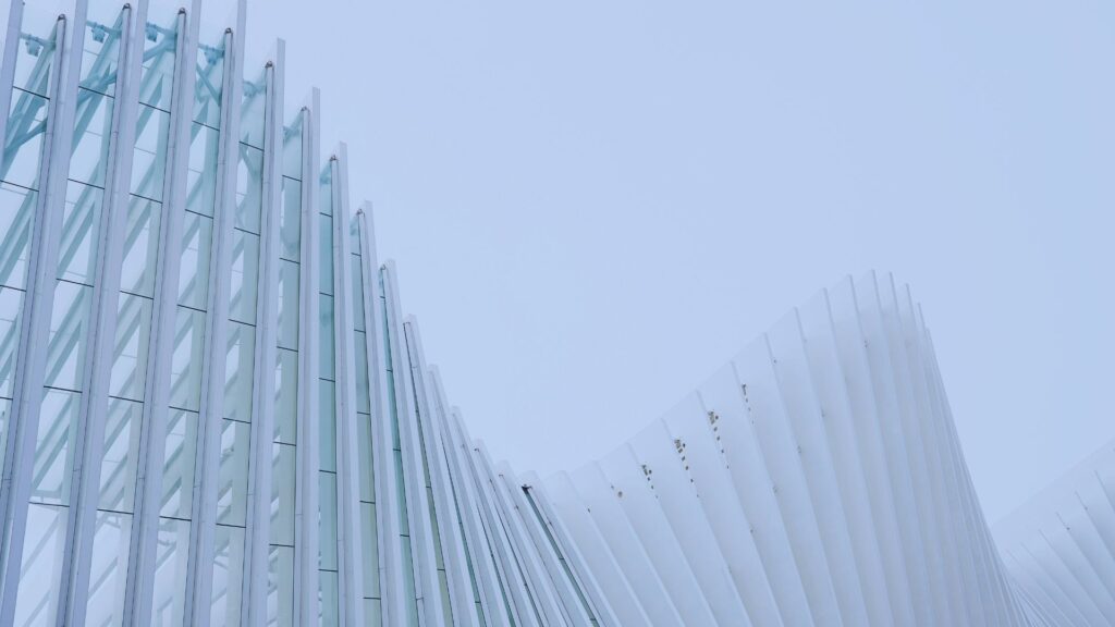 Facciata architettonica bianca a forma di onda contro un cielo chiaro