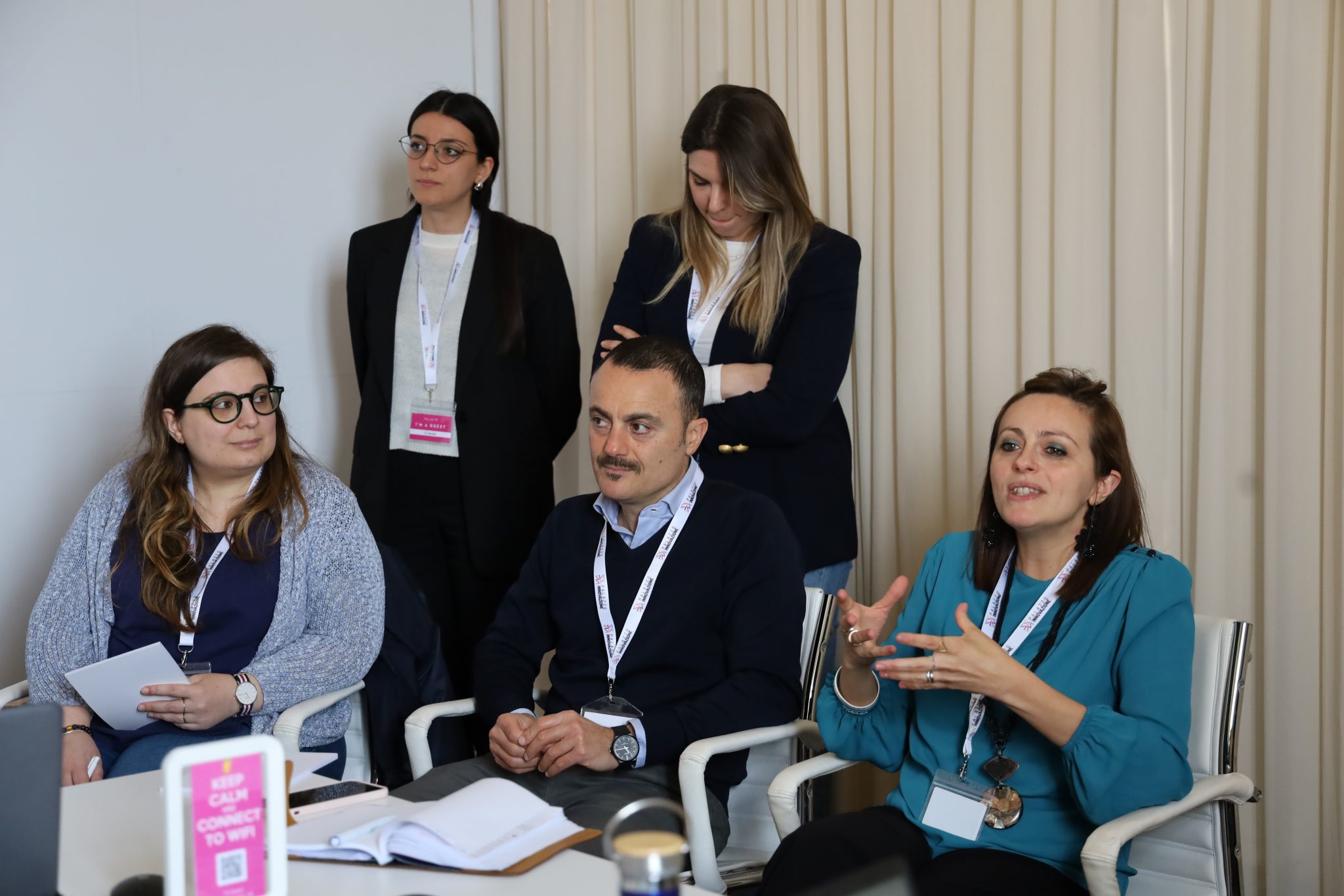 Gruppo di professionisti con badge seduti in una tavola rotonda di discussione