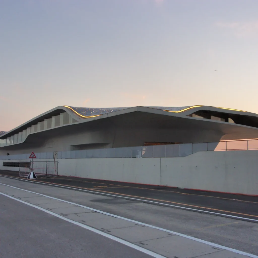 Edificio moderno dalla copertura curva al tramonto, vista dalla strada