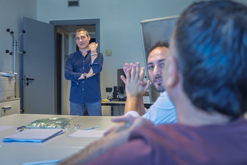 Formatore in piedi e partecipanti che applaudono durante la lezione