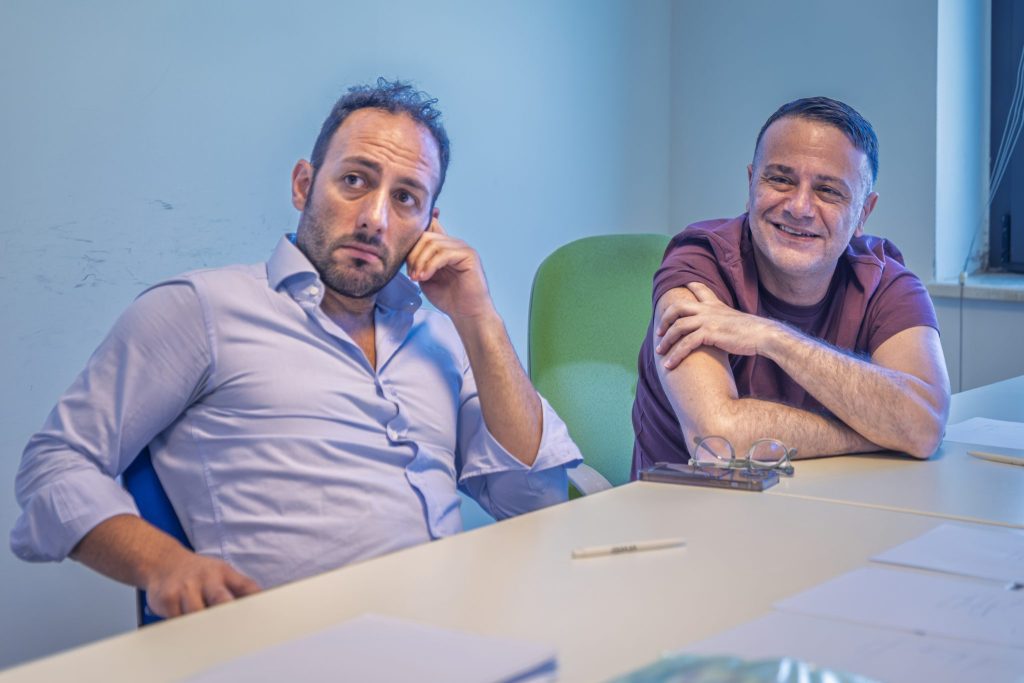 Due uomini seduti al tavolo ascoltano durante il corso di comunicazione