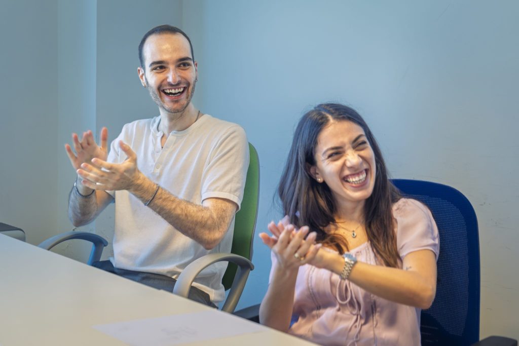 Un uomo e una donna ridono e applaudono durante il corso