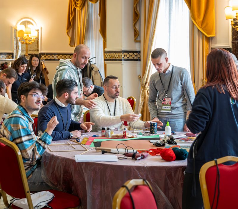 Partecipanti al lavoro attorno a un tavolo in una sala elegante